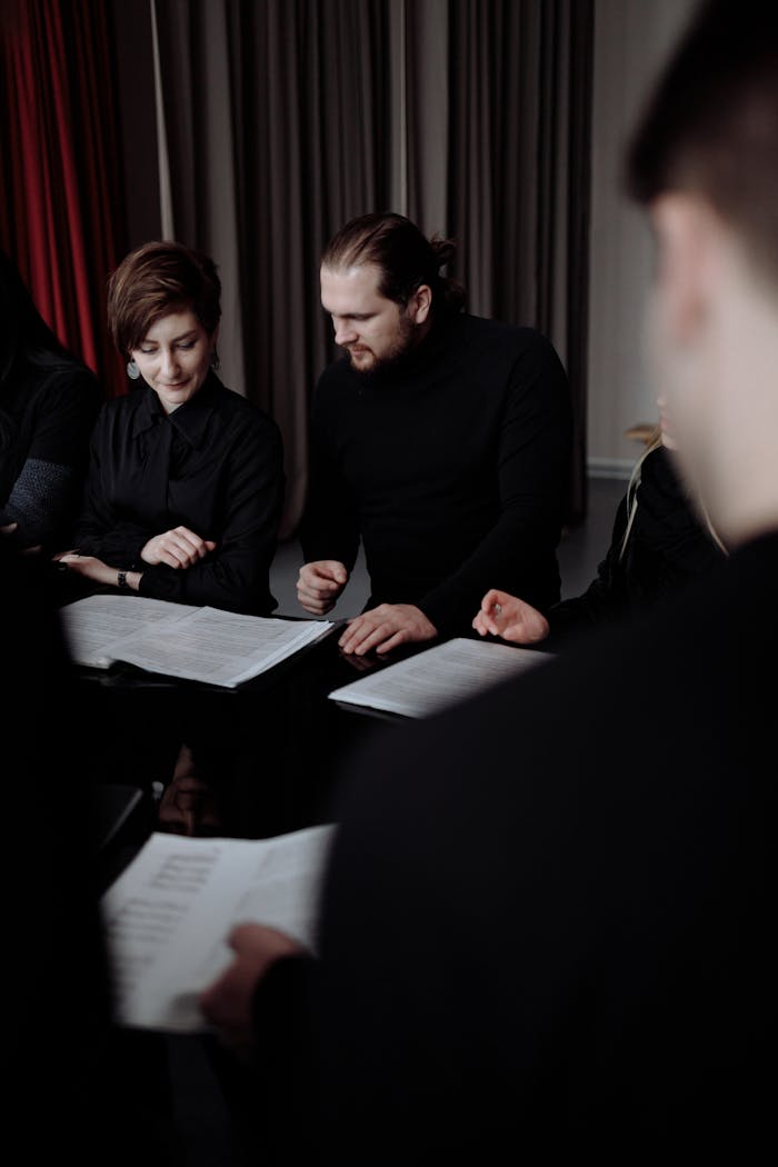A group of adults engaging in choir practice indoors with music sheets.